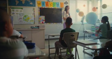 BTMM: Güzel Bayan Öğretmen Başlangıç Dersi, Modern Sınıfta Coğrafya Öğrencilerine Eğitim Veriyor. Zeki Çeşitli Çocuklar Masa başında oturuyor, Bilim okuyor, Öğretmeni dinliyor..