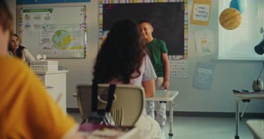 BTMM Yenilenebilir Enerji Sınıfı: Afrika kökenli Amerikalı Çocuk Sınıf Arkadaşları ve Öğretmenler Önünde Ekoloji Ödevini Sunuyor. İlköğretim Okulu Çocukları Sınıfta Bilim Dersinde Masalarda Oturuyorlar.