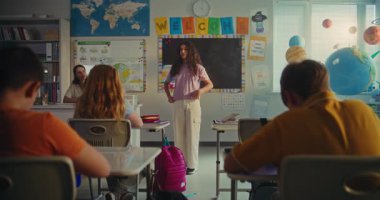 İlkokul kızı Ekoloji Bilgisi 'ni sınıfın önünde ve bayan öğretmen olarak gösteriyor. Modern Sınıfta Çevre Bilimi Dersinde Masalarda Oturan Zeki Çocuklar. STEM Eğitimi.