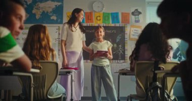 BTMM Yenilenebilir Enerji Sınıfı: İlkokul öğrencisini sunan Bayan Öğretmen. Not Defterli Akıllı Kız Sınıf Arkadaşlarının Önünde Ekoloji Sunumu Yapıyor. Doli Vuruşu.