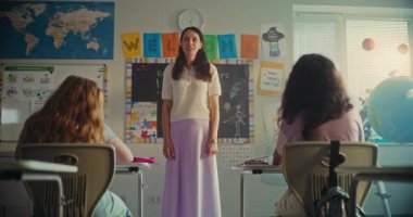 Modern Sınıfta Bilim Dersinde Genç Öğrenciyi Kurula Çağıran Bayan Öğretmen. Dijital tabletli akıllı ilkokul çocuğu sınıfın önünde ekoloji bilgisini gösteriyor. STEM Eğitimi.