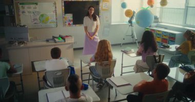 Çevre Bilimi Dersi: Zeki Çocuklara Ekoloji Eğitimi Veren Kadın Öğretmen. İlkokul çocukları cevap vermek için ellerini kaldırıyor, Modern Sınıfta öğrenim görüyor. BTMM Eğitim. Yüksek Açı Yavaş Hareketi