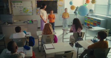 STEM Yenilenebilir Enerji Sınıfı: İlkokul öğrencileri Sınıf Arkadaşları ve Öğretmenlerle dolu Sınıfın Önündeki Enerji Kaynakları hakkında konuşuyor. Çeşitli Çocuklar Ekoloji ve Bilim okuyor. Yavaş Hareket