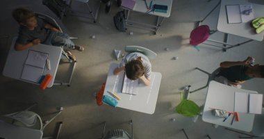 Sad İlköğretim Okulu öğrencisi, sınıf arkadaşları ona zorbalık ederken, gülerken ve kağıt fırlatırken masada oturup ağlıyordu. Toksik Okul Ortamı 'nda Akran Tacizi' nden muzdarip. Üst Görünüm Döndürülüyor.