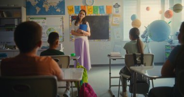 STEM Sınıfı: Kadın Öğretmen Derse Başlıyor, Çok Irklı Sınıfta İlkokul Çocuklarına Coğrafya Öğretiyor. Masalarda oturan, Fen Bilgisi Öğrenen Genç Kız ve Oğlanlar Grubu. Öğretmeni dinleyin..