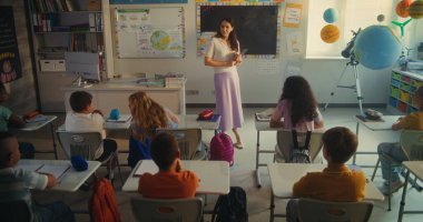 Çevre Bilimi Dersi: Tablet Bilgisayarlı Kadın Öğretmen Akıllı Çeşitli Çocukları Eğitiyor. İlkokul çocukları Yenilenebilir Enerji ve Güneş Sistemi 'ni Modern Sınıfta İnceleniyor. STEM Eğitimi.