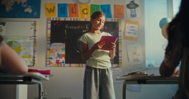 Modern Sınıfın Önünde Ekoloji Bilgisi ve Öğretmenini Gösteren Not Defteri 'ne sahip zeki ilkokul kızı. Çocuklar bilim dersi sırasında sunumdan sonra el çırpıyor. Doli Vuruşu.