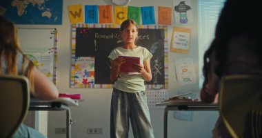 Modern Sınıfın Önünde Ekoloji Bilgisi ve Öğretmenini Gösteren Not Defteri 'ne sahip zeki ilkokul kızı. Çocuklar bilim dersi sırasında sunumdan sonra el çırpıyor. Doli Vuruşu.