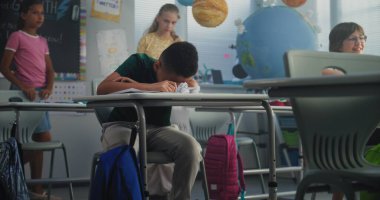 Üzgün Afro-Amerikan İlköğretim Okulu öğrencisi, sınıf arkadaşları ona zorbalık yaparken, gülerken ve kağıt fırlatırken tek başına masada oturuyor ve ağlıyor. Okuldaki zorbalık ve duygusal istismardan muzdarip.