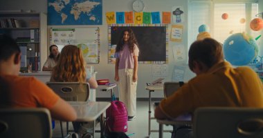 STEM Yenilenebilir Enerji Sınıfı: İlkokul öğrencisini kurula çağıran kadın öğretmen. Yetenekli Kız Çeşitli Çocuklar ve Sınıf Arkadaşlarıyla dolu Sınıfın Önünde Ekoloji Ödevini Sunar.