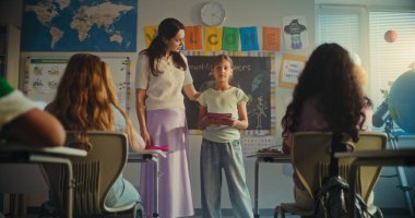 BTMM Yenilenebilir Enerji Sınıfı: İlkokul öğrencisini sunan Bayan Öğretmen. Not Defterli Akıllı Kız Sınıf Arkadaşlarının Önünde Ekoloji Sunumu Yapıyor. Doli Vuruşu.