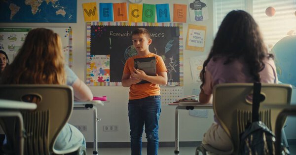 Учительница приглашает молодого студента на занятия по естественным наукам в современном классе. Умный первоклассник с цифровыми знаниями экологии перед классом. STEM Образование.