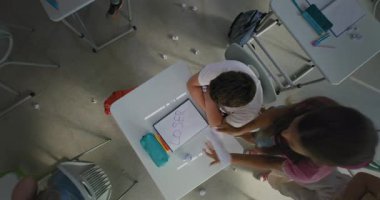 Agresif Sınıf Arkadaşları Depresyondaki İlköğretim Çocuğu Tek Başına Masada Otururken Kağıtları Atan ve Gülen Çocuklar. Toksik Okul Ortamı 'nda Duygusal ve Fiziksel Taciz. Üst Görünüm Döndürülüyor.