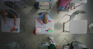 Okul Not Defteri 'nde İlkokul Kızı Çizimi Üzerine En İyi Görünüm. Masaların arasında koşan, ders öncesi oyun oynayan ve eğlenen çocuklar. Modern okulda etkileşimli öğrenim