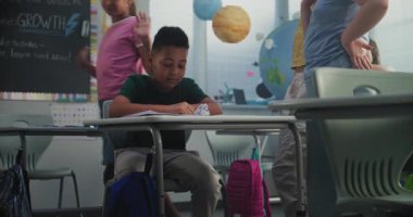 Üzgün Afro-Amerikan İlköğretim Okulu öğrencisi, sınıf arkadaşları ona zorbalık yaparken, gülerken ve kağıt fırlatırken tek başına masada oturuyor ve ağlıyor. Okuldaki zorbalık ve duygusal istismardan muzdarip.