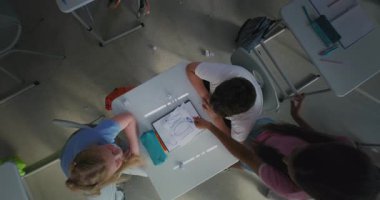 Sınıf arkadaşları zorbalığa maruz kalıyor İlköğretim Okulu çocuğu Masada oturuyor ve ağlıyor: Gülüyorlar ve kağıtları fırlatıyorlar. Akran Tacizi, Duygusal ve Fiziksel Taciz 'den muzdarip. Üst Görünüm Döndürülüyor.