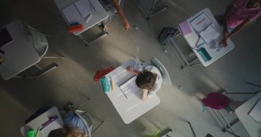 Agresif Sınıf Arkadaşları Depresyondaki İlköğretim Çocuğu Tek Başına Masada Otururken Kağıtları Atan ve Gülen Çocuklar. Toksik Okul Ortamı 'nda Duygusal ve Fiziksel Taciz. Üst Görünüm Döndürülüyor.