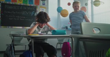 Hüzünlü ilkokul öğrencisi, sınıf arkadaşları ona zorbalık yaparken yalnız başına oturuyor ve ağlıyor, gülüyor ve kağıtları fırlatıyor. Okul zorbalığından, arkadaş tacizinden ve duygusal mücadeleden muzdarip.