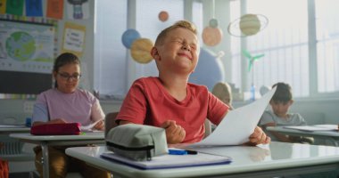 Modern Sınıfta Masalarda Oturan İlkokul çocuklarına Okul Sınavı Sonuçları Veren Öğretmenler. Coğrafya veya Fen Bilimleri Sınavı 'nda Harika Notlar Aldı ve Kutladı.