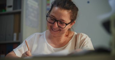 Bayan Öğretmen Notlama Görevleri ya da Okul Çocukları Ödevleri Dersten Sonra Sınav kağıtlarını kontrol etmek. Masada oturan, Boş Sınıfta Tek Başına Çalışan, İlkokulda Öğretmenlik yapan.