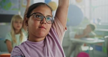 İlköğretim Okulu Kızı Masada Otururken, El Kalkmış ve Öğretmenler Coğrafya Dersinde Sorulara Cevap Veriyor. Modern Sınıfta Çevre Bilimi okuyan Zeki Çeşitli Çocuklar Takımı