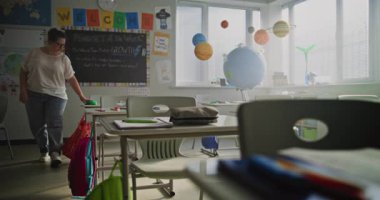 Boş Sınıfta Masada Tek Başına oturan Yorgun Bayan Öğretmen, Ders ve Zor Okul Günü 'nden sonra dinleniyor. Kadın Stres Duyuyor, Yanıyor ve Duygusal Mücadele Modern İlkokulda Çalışıyor.