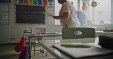 Sınıf Öncesi Öğrenci Masaları Üzerine Yazma Görevi Veren Bayan Öğretmen. Öğretmenler Sınıfta Ders ya da Sınav Alanını Hazırlıyor. Modern İlkokulda Çalışan Kadın.