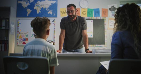 Учитель мужского пола сдаёт экзамен по успеваемости матери ученика начальной школы. Учитель, восхваляющий юношу за академический прогресс и высокие оценки. Встреча в поддержку развития детей. Долли Шот.