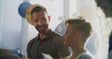 Anne ve Baba, Okul Aile Gecesi boyunca Oğullarının Test Sonuçlarına Bakıyorlar. Mükemmel Akademik Performans ve İlkokul çocuğunun Davranışları hakkında mutlu ebeveynler. Ağır çekim. Kapat..