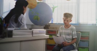 Bayan Öğretmen Okul Sınavını İlkokul Öğrencisine Sunar, Genç Çocukla Düşük Notlar ve Akademik Başarısızlık Tartışması. Çocukların Gelişmesini Desteklemek İçin Sınıf Arası Toplantı. Orta Çekim.