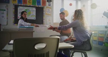 Genç Çocuğun Okul Sınavı Sonuçlarını Ailesine Veren Bayan Öğretmen. İlköğretim Okulu Öğrencisinin Sınıfta Akademik Başarısızlığını Tartışan Öğretmen ve Ebeveynler. Çocuk Gelişimini Desteklemek İçin Toplantı