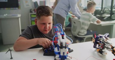 İlköğretim okulunda okuyan çocuk, Yenilikçi Robot Kollar 'ın İnceleme Modeli. Sınıfta Akıllı Genç Öğrenci Bilim, Mühendislik ve Gelişmiş Teknolojiler okuyor. Etkileşimli BTMM Dersi.
