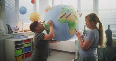 Çevre Bilimi Dersi: İlkokul çocukları Dünya Modeline Minyatür Bulutlar ve Rüzgar Türbinleri Ekliyor. Modern Sınıfta Yetenekli Çocuklar Yenilenebilir Enerji Kaynakları Öğreniyor. STEM Eğitimi