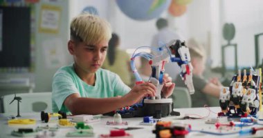 Yenilikçi Robot Kol 'un İlkokul Çocuğu İnceleme Modeli, Mühendis Olmanın Rüyası. Sınıfta Akıllı Genç Öğrenci Bilim, Mühendislik ve Teknoloji okuyor. Etkileşimli BTMM Dersi.