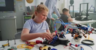 Masada oturan ilkokul öğrencisi kız, Yenilikçi Robot Kollar 'ın İnceleme Modeli. Sınıfta Akıllı Genç Öğrenci Bilim, Mühendislik ve Gelişmiş Teknolojiler okuyor. Etkileşimli BTMM Dersi