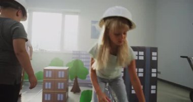 Büyük Mukavva Şehir Modelleri, Yollar, Ağaçlar, Binalar ve Şehir Planlama ile İlköğretim Okulu Öğrencileri Hareketli Bloklar. Bayan Öğretmenler Organizasyonu Yaratıcı BTMM Sınıfı. El bilgisayarı.