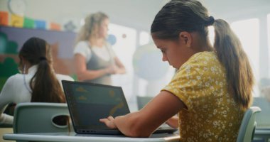 Geniş Dijital Ekran Kullanarak Sanat Dersinde Genç Çocuklara Rehber Bayan Öğretmen. İlkokul kızı Laptop 'ta çizim yapıyor, Modern Sınıfta Dijital Yetenekler Çalışıyor. Yaratıcı BTMM Öğrenme.