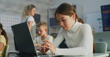 İlköğretim Okulu Kızı Laptop Kullanıyor, Modern Sınıfta Dijital Sanat Dersinde Proje Oluşturuyor. Dijital Gadget 'lar üzerine yaratıcı işler yapan genç öğrenciler. Etkileşimli ve Yenilikçi BTMM Eğitimi.