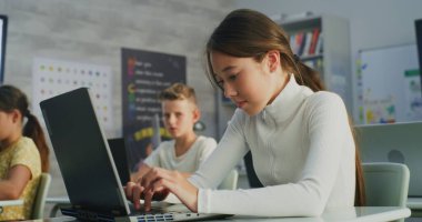 İlköğretim Okulu Kızı Laptop Kullanıyor, Modern Sınıfta Dijital Sanat Dersinde Proje Oluşturuyor. Dijital Gadget 'lar üzerine yaratıcı işler yapan genç öğrenciler. Etkileşimli ve Yenilikçi BTMM Eğitimi.