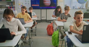 İlkokul öğrencileri dizüstü bilgisayarlarda yaratıcı projeler üzerinde çalışıyor, Sanat sınıfında dijital beceriler geliştiriyor. Resim Oluşturmak için Yapay Zeka Yazılımını Gösteren Dijital Ekran. İnteraktif STEM Öğrenme. Doli Vuruşu