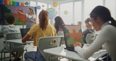 İlkokul öğrencileri Modern Sınıfta Dizüstü bilgisayarlarda Dijital İllüstrasyonlar Yaratıyorlar. Dijital Ekran kullanarak Sanat Dersinde Genç Çocuklara Öğretmek. BTMM Yaratıcılık ve Hayal Gücü Öğrenme.