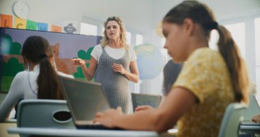 Laptop 'ta İlkokul Kızı Çizimi, Modern Sınıfta Dijital Yetenekler Uygulaması. Dijital Ekran Kullanarak Sanat Dersinde Genç Çocuklara Rehber Öğretmenlik Yapıyor. Yaratıcı BTMM Öğrenme.