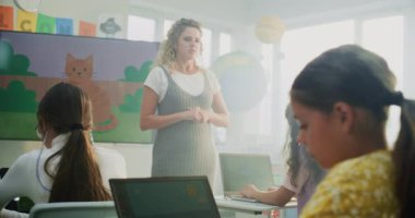 İlkokul öğrencisi kız Modern Sınıfta Dijital Sanat sınıfında dizüstü bilgisayarda resim çiziyor. Genç Öğrencileri Eğiten, Dijital Ekranda Yaratıcı Öğrenim Gösteren Öğretmen. Etkileşimli BTMM Eğitimi