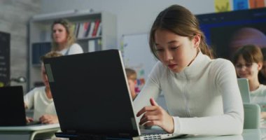 İlköğretim Okulu Kızı Laptop Kullanıyor, Modern Sınıfta Dijital Sanat Dersinde Proje Oluşturuyor. Dijital Gadget 'lar üzerine yaratıcı işler yapan genç öğrenciler. Etkileşimli ve Yenilikçi BTMM Eğitimi.