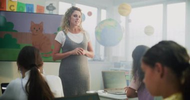 Geniş Dijital Ekran Kullanarak Sanat Dersinde Genç Çocuklara Rehber Bayan Öğretmen. İlkokul kızı Laptop 'ta çizim yapıyor, Modern Sınıfta Dijital Yetenekler Çalışıyor. Yaratıcı BTMM Öğrenme.