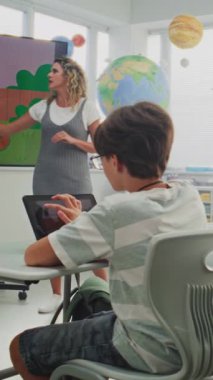 İlkokul çocukları dijital sanat dersinde dizüstü bilgisayarlara resim çiziyor. Öğretmen Öğrencileri Eğitmek, Dijital Ekranda Yaratıcı Öğrenme Göstermek. Etkileşimli BTMM Eğitimi. Dikey Çekim. 