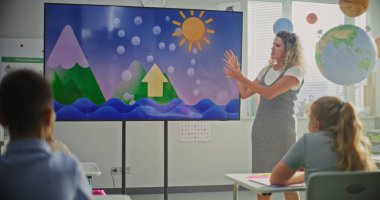 İlkokul öğrencileri Modern Sınıfta Hava Durumu Faktörleri Hakkında Temel Bilgiler Çalışıyor. Coğrafya Dersi Sırasındaki Akıllı Çocuklara Su Döngülerini Açıklayan Bayan Öğretmen Dijital Ekran Kullanıyor.