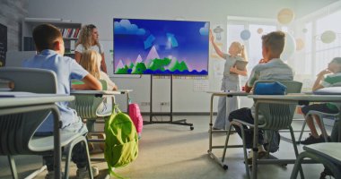 Tablet bilgisayarlı ilkokul kızı sınıfın önünde coğrafya bilgisi gösteriyor ve öğretmen dijital ekranı kullanıyor. Sınıfta Su Döngüleri ve Hava Durumu Faktörlerini Öğrenen Genç Öğrenciler.