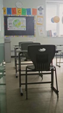 Modern İlköğretim Okulu 'nun Öğrenci Masaları, Chalkboard, Asılı Güneş Sistemi Modelleri ve Renkli Posterleri olan İçi. Çocuklar için Eğitici Öğrenme Ortamı. Dikey Çekim.