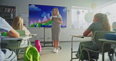 Coğrafya Sınıfı: Tablet Bilgisayarlı Kadın Öğretmen İlkokul Çocuklarına Dijital Ekran Kullanarak Öğretiyor. Oturan ve Su Döngülerini Öğrenen Genç Erkekler ve Kızlar Grubu, Hava Durumu Faktörleri. Doli Vuruşu